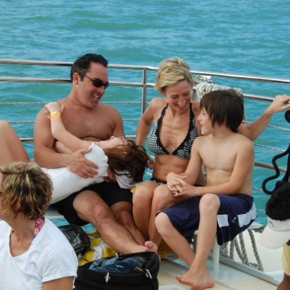 a group of people sitting on a bench next to a body of water