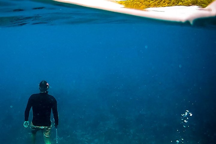 a man standing next to a body of water