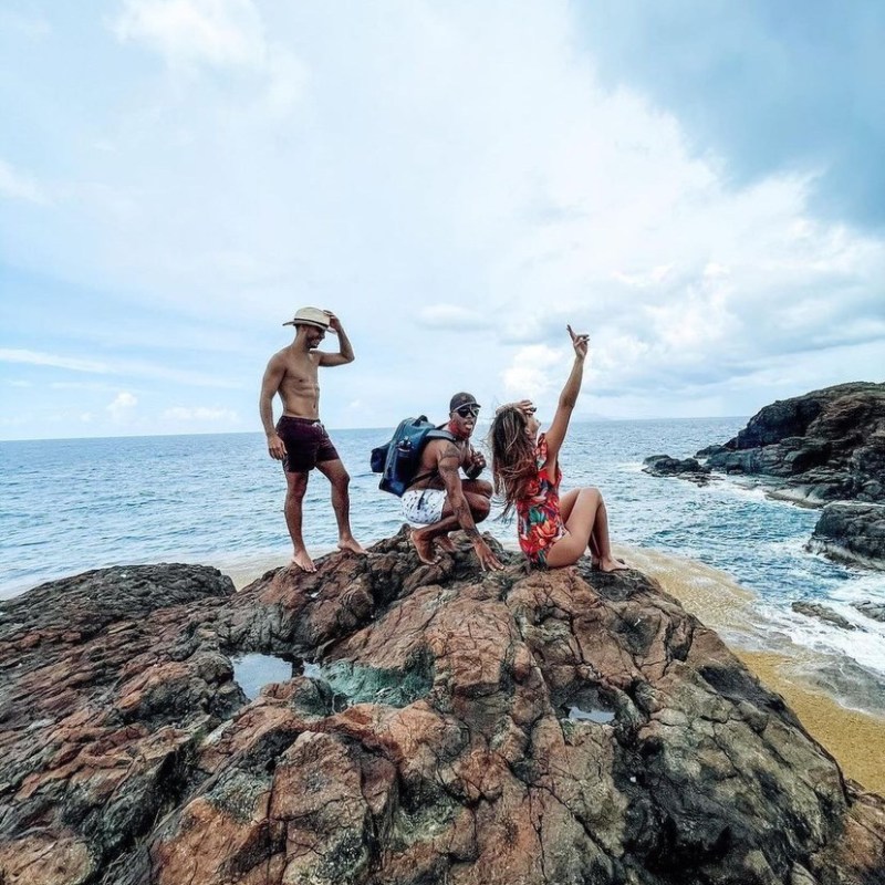 a group of people standing on a rocky beach