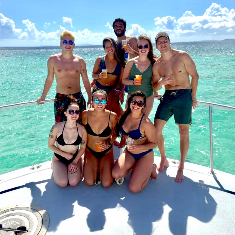 a group of people on a beach posing for the camera