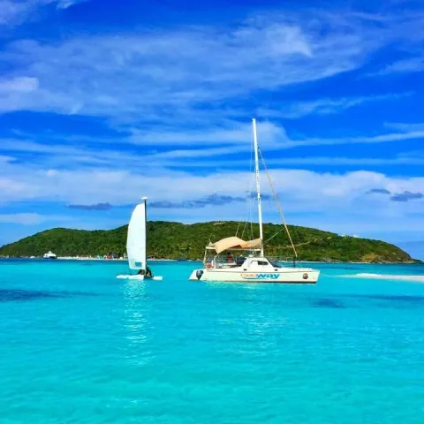 a blue and white boat sitting next to a body of water