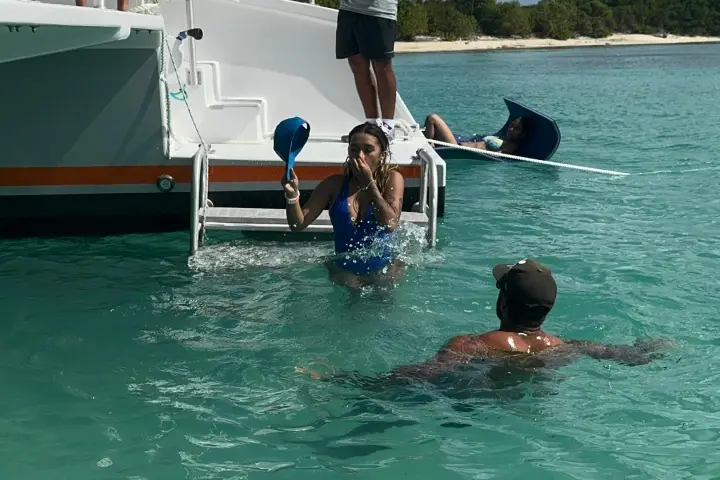 a group of people riding on the back of a boat in the water
